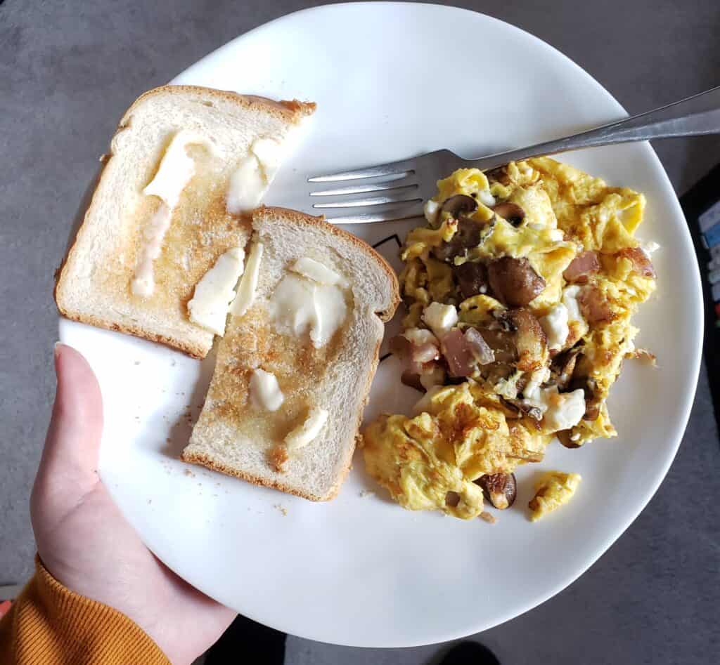 An egg scramble with toast on a plate.
