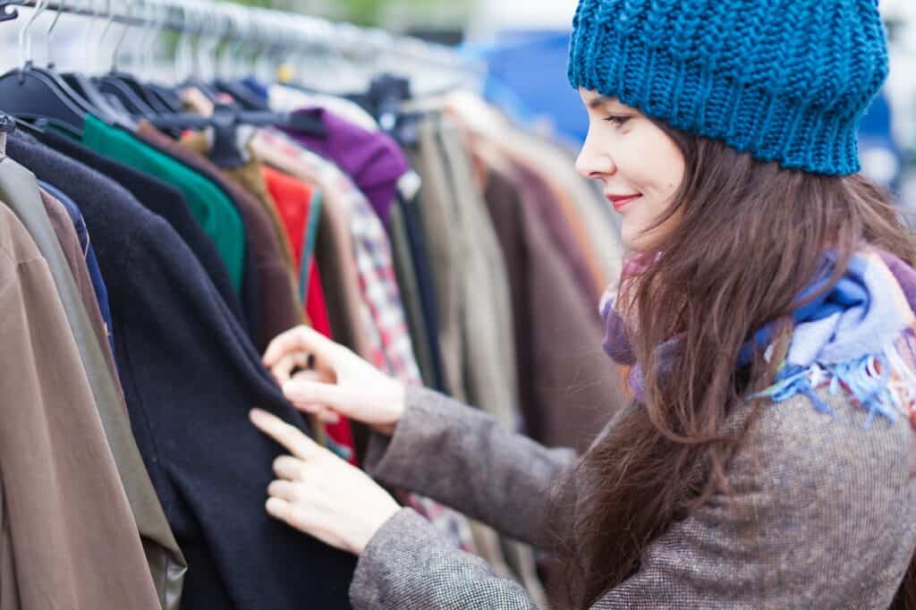 A woman looking through clothes at a flea market to re-sell.